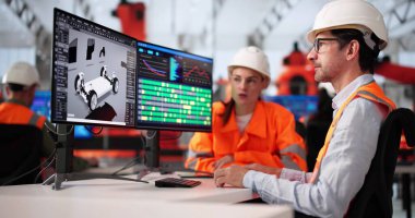 Bilgisayarda elektrikli araba modeli geliştiren çeşitli mühendisler grubu.