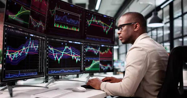 Afrikalı Komisyoncu Çevrimiçi Finansal Aktarımları Kontrol Etmek İçin Çoklu Ekran Kullanıyor.