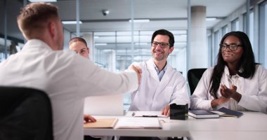 Tıbbi ekip, yeni sağlık ortaklığı için Afro-Amerikan doktorla röportaj yapıyor.