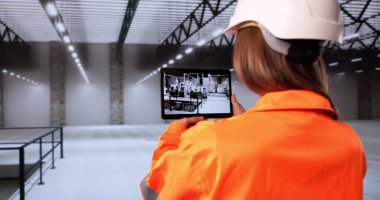 Kadın Tasarımcı Endüstriyel Katları AR Teknoloji Fabrikası Planlama için tarıyor.