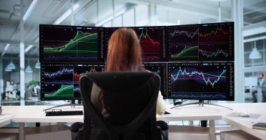 Çoklu Bilgisayar Monitörlerindeki Profesyonel İşkadını Verileri Analiz Ediyor