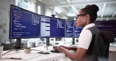 Genç Afrikalı Amerikalı Kadın Masaüstü Bilgisayar Ekranında Yazılım Geliştiriyor.