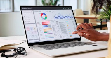 Bütçe uygulaması ile dizüstü bilgisayarında finansmanı yöneten genç bir kadın..