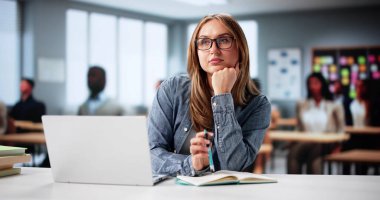 Endişeli üniversite öğrencisi derslerine odaklanmak için çabalıyor. Kalabalık Okul Kütüphanesinde İlgili Öğretmen Notları Belgeleri.