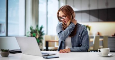 Bilgisayarın arkasında kötü duruşu olan Ergonomik Sandalye kullanan kadın, boyun ağrısı. Muhtemel Meslekler: Ofis İşçisi