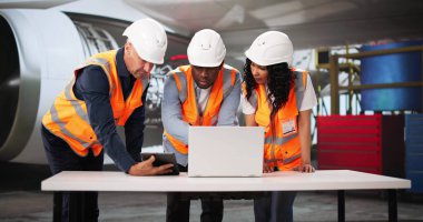 Çok ırklı Havacılık Ekibi, dizüstü bilgisayar kullanarak Hangarda Uçak Güvenliğini Kontrol Ediyor