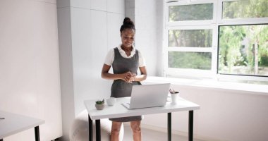 Afrikalı Amerikalı İş Kadını Ofis Masasındaki Yüksekliği Ayarlıyor