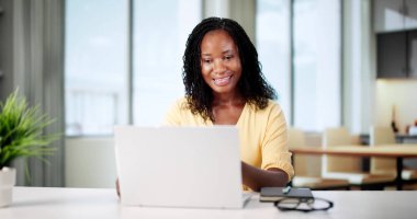 Kadın Afrikalı CEO dizüstü bilgisayarla sanal toplantı düzenliyor.