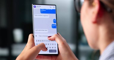 Genç Kadın Smartphone uygulamasını kullanarak mesaj gönderiyor..