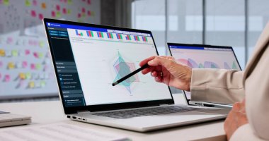 Kıdemli iş kadını şirket masasında mali verileri analiz ediyor.