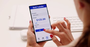 Genç kadın internetten cep telefonu banka hesabını kontrol ediyor.