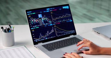 Ofisteki bilgisayardaki borsa verilerini analiz eden genç bir borsacı..