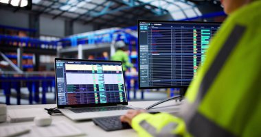 Depo işçisi envanter ve siparişleri yönetmek için lojistik yazılım kullanıyor. İş yerindeki Kadın Hesap Tablolarını İzliyor