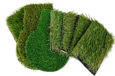 Beyaza izole edilmiş yapay çimen örneklerini kapatın.