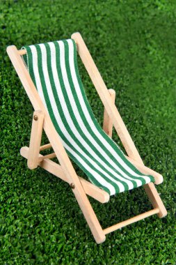 Yeşil çimenli mini şezlonga yakın durun.
