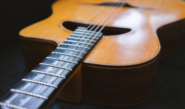 Eski bir çingene akustik gitarı mavi bir koltukta.