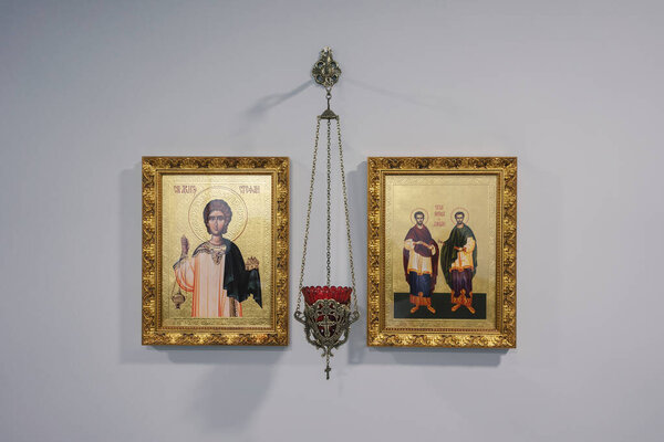 Чачак, Сербия - 31 января 2025 года: золотая лямпа и две звезды на белой стене. Узнаваемые предметы православного наследия в сербском доме.