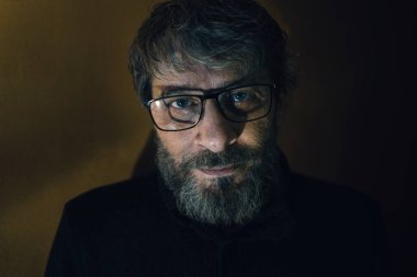 Yüzünde endişeli ve ilgili bir ifadeyle gözlük takan orta yaşlı bir adamın etkileyici portresi..