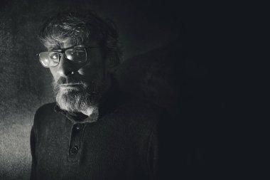 Yüzünde endişeli ve ilgili bir ifadeyle gözlük takan orta yaşlı bir adamın etkileyici portresi..