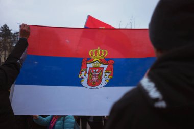 Sırp bayrağı iki adamın arasından geçti, sokakta, dikiz manzaralı..