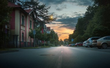 Cacak, Sırbistan - 04 Mayıs 2025: Cacak 'ta parkın yanındaki sokak, gün batımı, bahar dönemi.