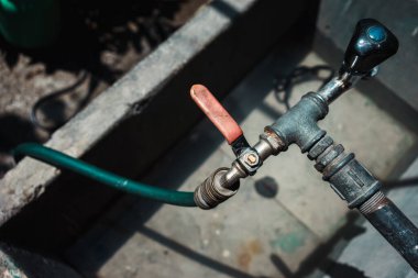 Bahçesinde çiçekleri sulamak için bir hortum olan bir çeşme..