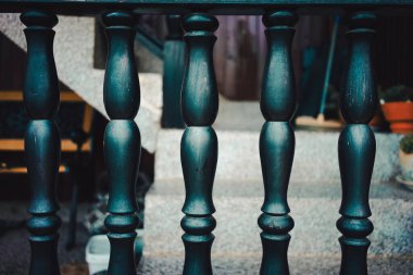 Beş tane eski siyah sütun dekoratif ahşap çit, arka planda ev terası..