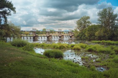 Sırbistan 'ın Cacak kenti yakınlarındaki Zapadna Morava nehri üzerinde yaya geçidi bulunan eski barajın manzarası.