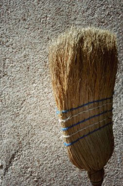 Eski bir duvarın önündeki süpürge başı, yakın görüntü, boşluğu yan tarafa kopyala.