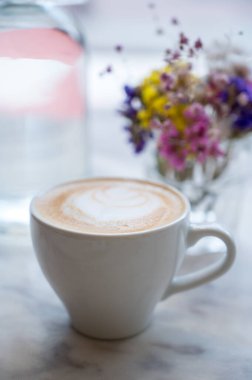 Kapuçino ve narin kır çiçekleriyle sakin ve rahat bir atmosferi çağrıştıran minimalist bir natüralist..