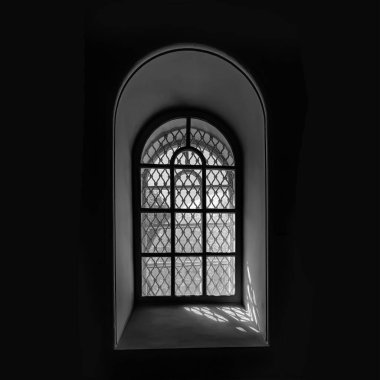 Minimalist square composition of arched window with decorative iron lattice, strong sunlight and shadow contrast in black and white style.