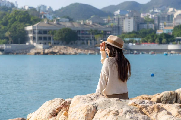 観光客の女性は岩の上に座って 香港市のスタンレーで海の景色を楽しむ — ストック写真