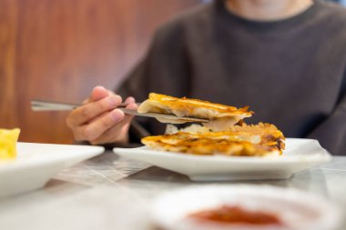 Kadın lokantada ızgara köfte yiyor.