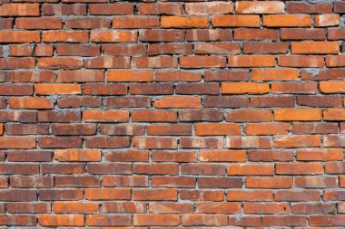 Binanın dışındaki kırmızı tuğla duvar.