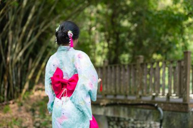 Japon kadın açık hava parkında yukata giyiyor.