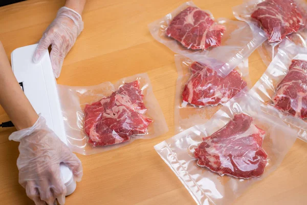 Raw beef meat sealed in plastic shrink wrap with vacuum sealer