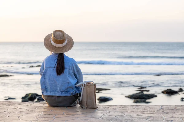 Turist Kadın Gün Batımında Deniz Kenarında Oturur — Stok fotoğraf