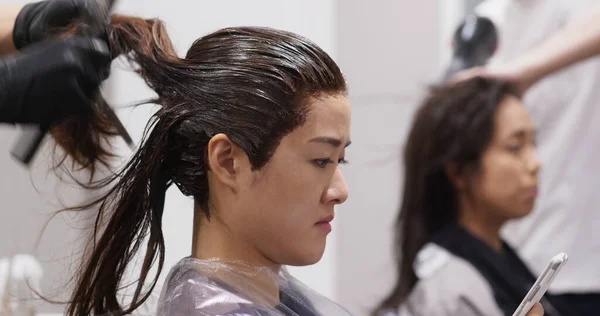 Girls go hair salon together, chatting and having hair treatment together at salon