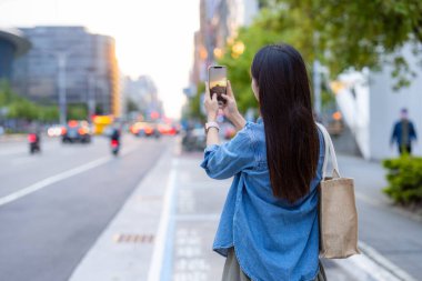 Woman take photo on the street in Taipei city