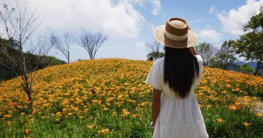 Turist kadın güzel bir portakal çiçeği ile Taimali 'yi ziyaret ediyor.