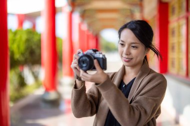 Travel woman use digital camera to take photo in Chinese temple
