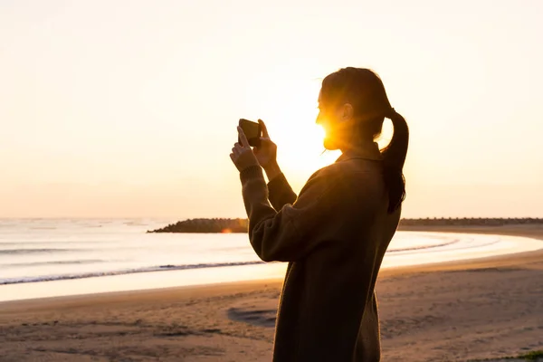 Силуэт Женщины Использует Камеру Сфотографироваться Закате Пляже — стоковое фото