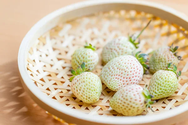 White strawberries nestled on a basket