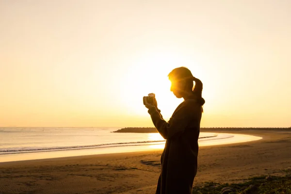 Silueta Ženy Použití Digitálního Fotoaparátu Fotit Západem Slunce Pláž Pozadí — Stock fotografie