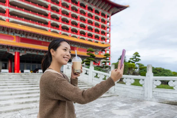 女性は台湾の大ホテルでバブルミルクティーと携帯電話で自撮り — ストック写真