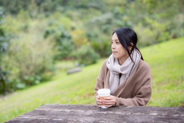 Kadınlar açık kafede kahvelerini yudumlarlar.