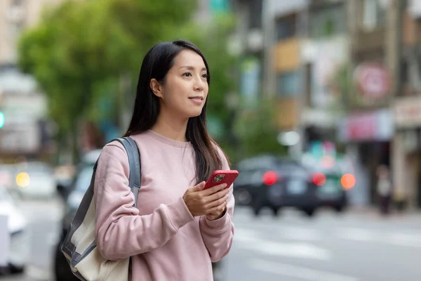 Woman find the location on cellphone in the city