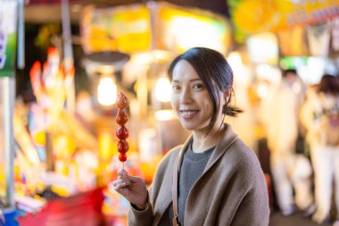 Geleneksel Çin sert karamel kaplı çilekli şiş Tanghulu kadın.