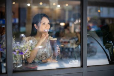 Kadınlar kahve dükkanında bir fincan kahvenin tadını çıkarır.