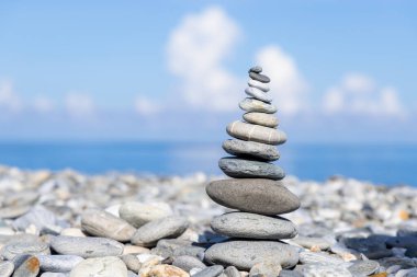 Pebble tower balance harmony stones arrangement on sea beach coastline